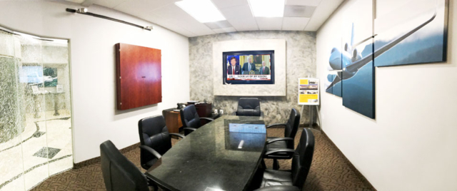 Conference room with big crystalized glass window, an enclosed dry erase board and flat screen tv