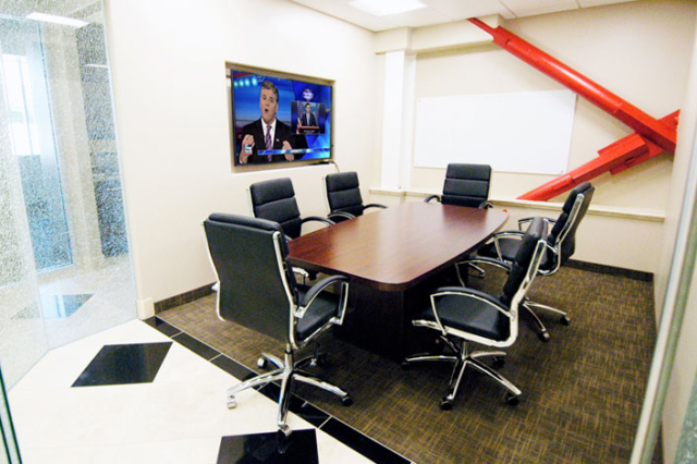 Conference room for rent with high ceilings, a conference table and mounted flat screen TV